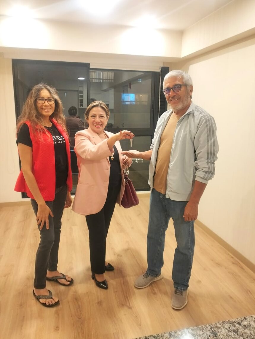 Carmen Antón entregando las llaves a una pareja de propietarios