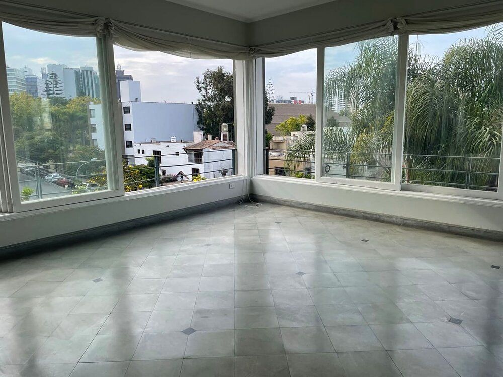Sala con ventanales y vista en un departamento de San Isidro